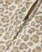 A close up of a light natural colored leopard print dress with a zippered back
