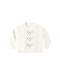 A natural colored sweater with a floral design down the center shown on a white background