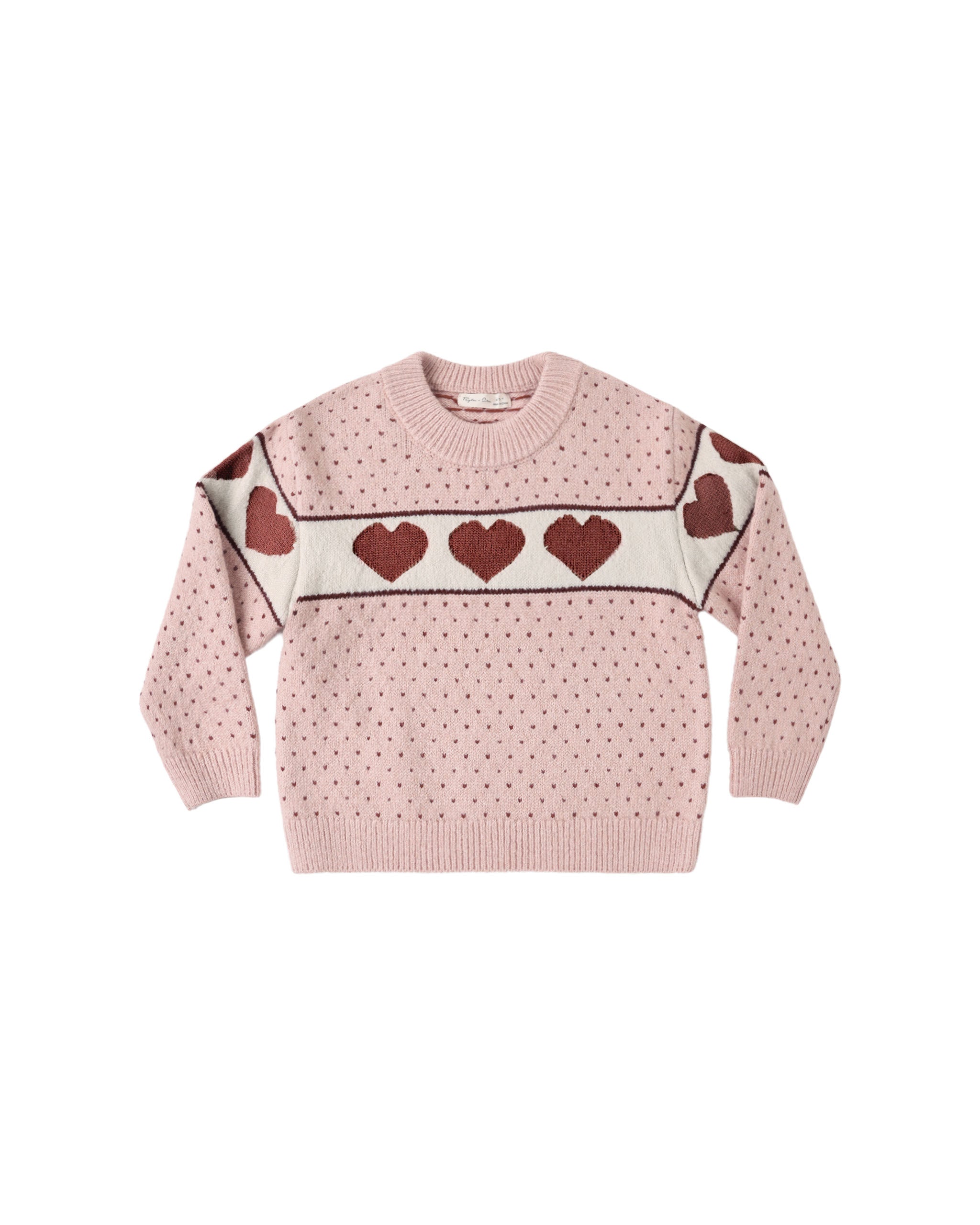 A blush colored sweater with red hearts on a white stripe shown on a white background.