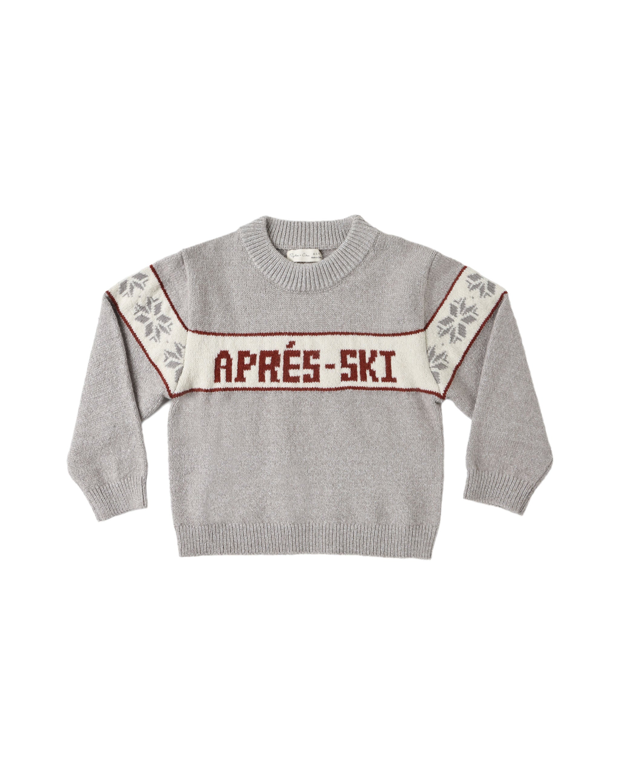 A light gray knit crewneck sweater with a cream horizontal chest stripe reading 'APRÉS-SKI' in dark red letters, bordered by thin red lines. The sleeves have cream panels with gray floral motifs and red trim.