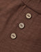 Close-up of a brown textured fabric garment with three round natural wood buttons aligned vertically.