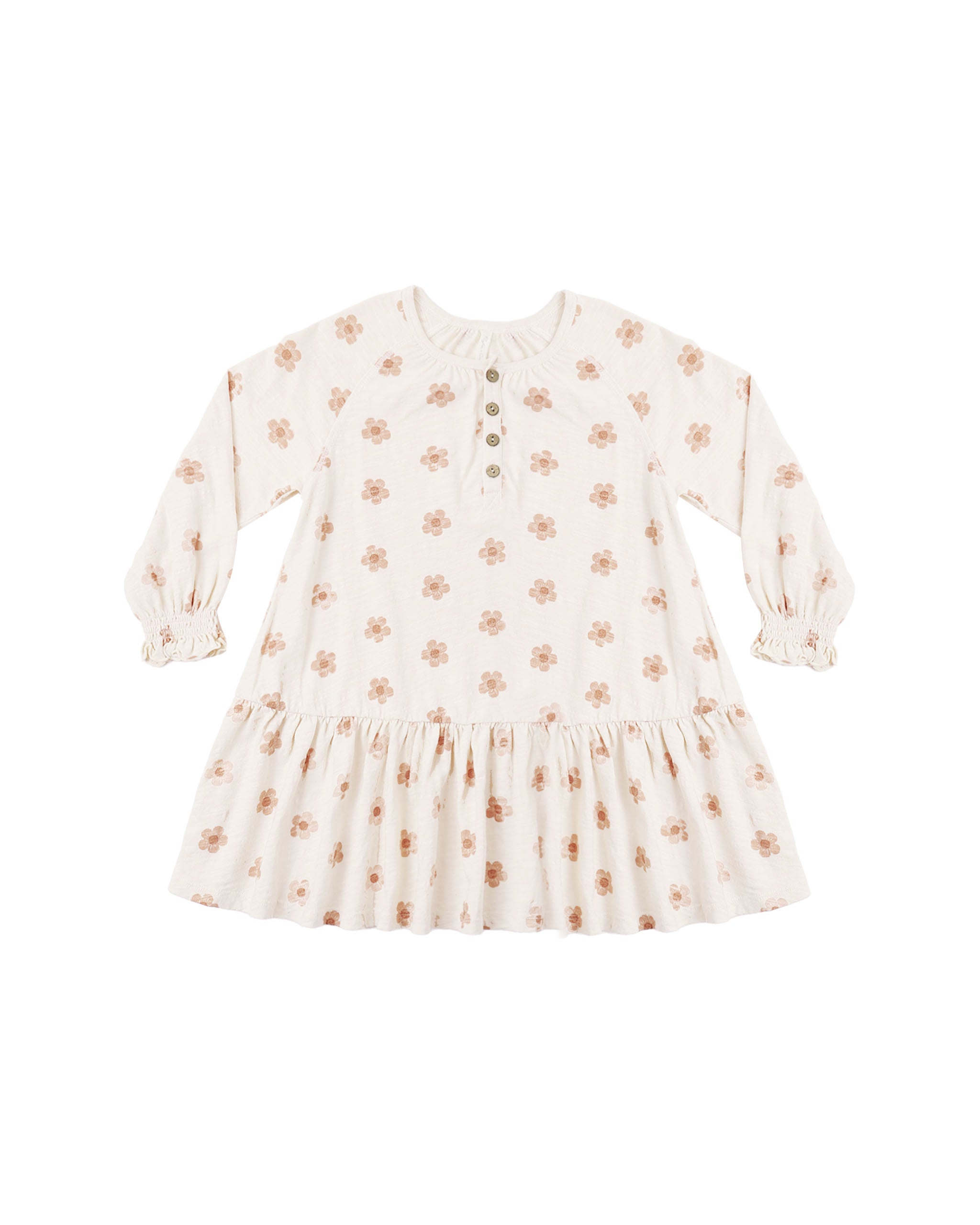 A long sleeve swing dress featuring a gathered lower tier, cinched wrists, and coconut button snaps down the front shown on a white background