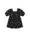 A black denim babydoll dress with a white daisy pattern on a white background.