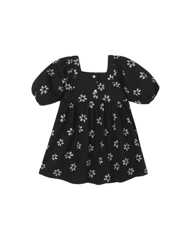 A black toddler girl's dress with a white floral pattern, featuring puff sleeves, a square neckline, and three small decorative buttons at the collar.