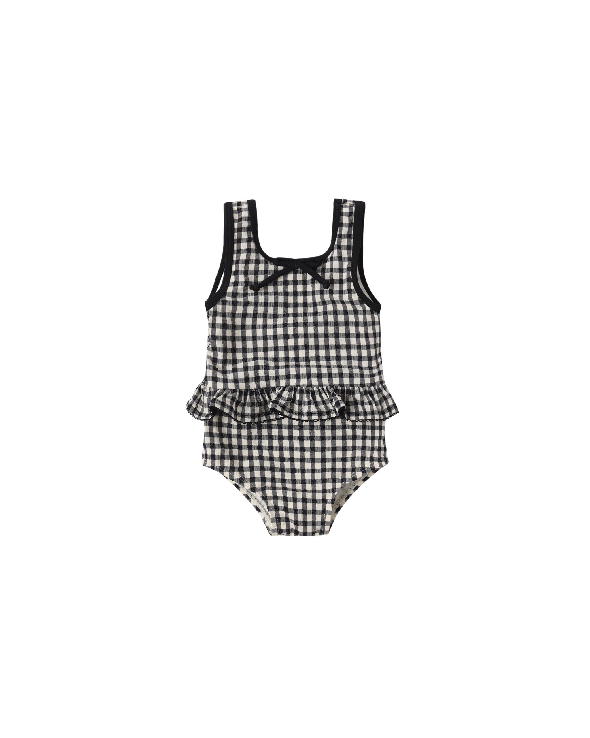 Black and white checkered swimsuit with ruffled details on a white background