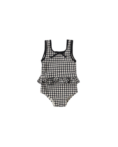 Black and white checkered swimsuit with ruffled details on a white background