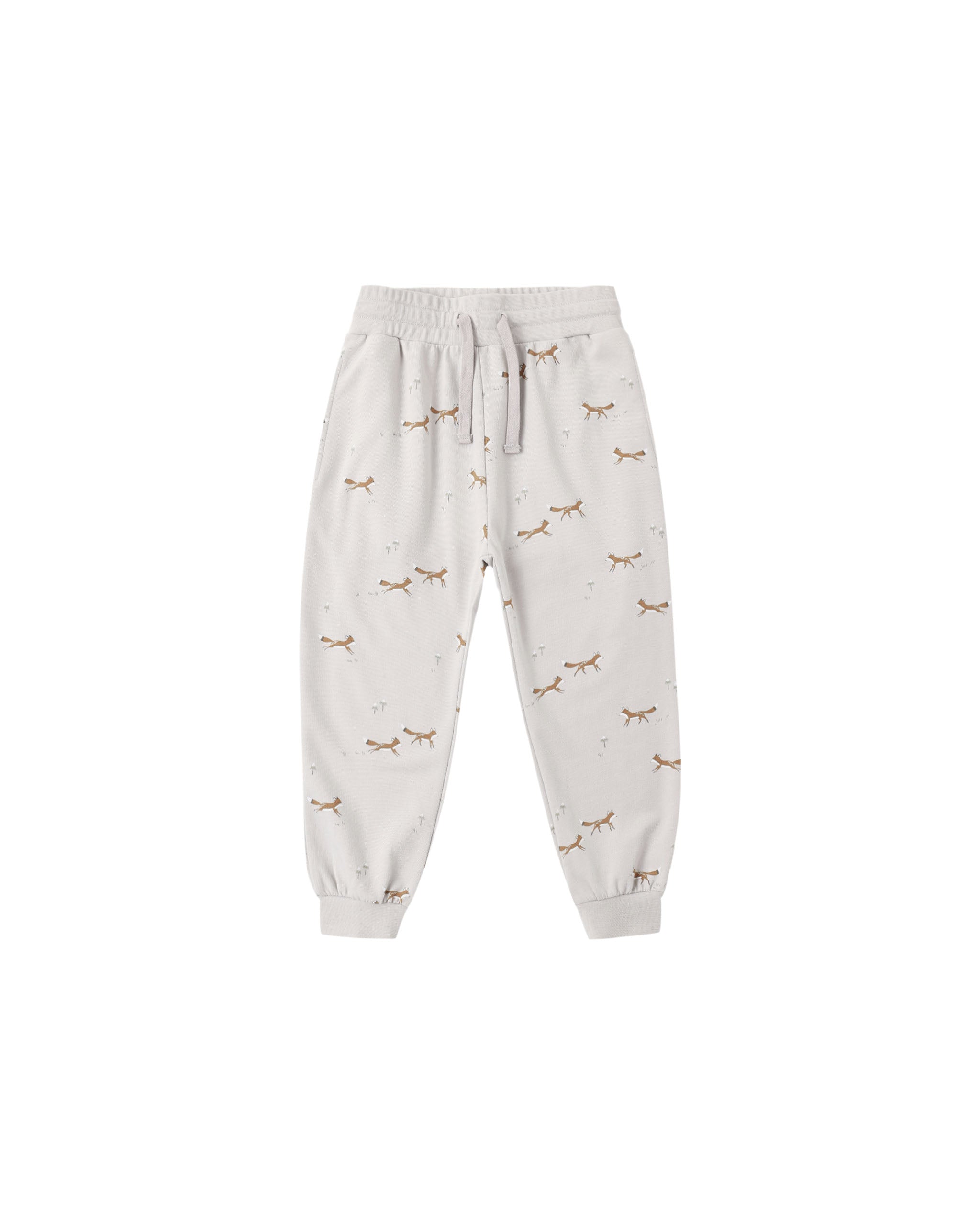 A pair of light beige jogger pants with an all-over print of small brown foxes and tiny dandolions, featuring an elastic waistband with a drawstring and elastic cuffs.