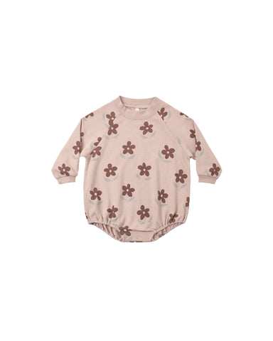 A baby long-sleeve romper in a dusty pink color, decorated with a repeating pattern of dark brown flowers with light gray centers, shown against a plain white background.