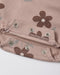 Close-up of a dusty pink fabric garment with a brown floral print and silver metal snap buttons.