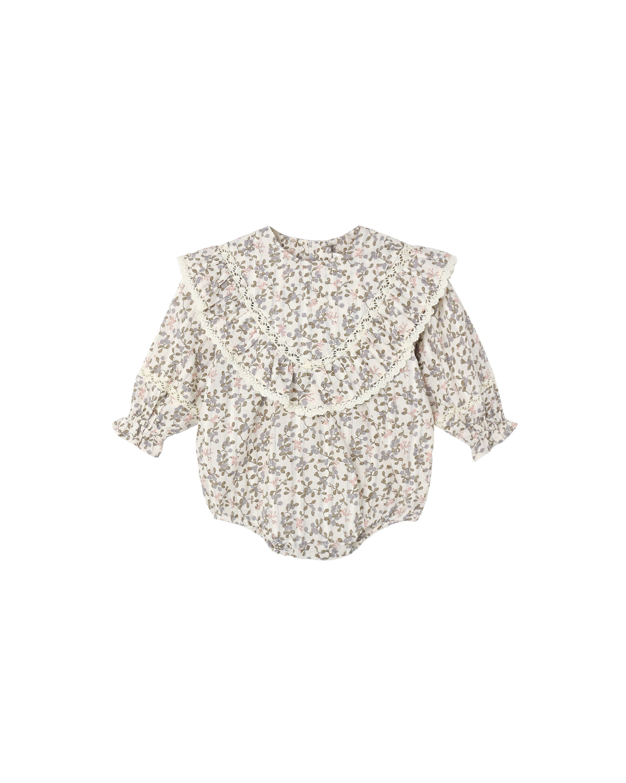 An ivory colored romper with a small floral pattern with a ruffle front shown on a white background.