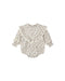 An ivory colored romper with a small floral pattern with a ruffle front shown on a white background.