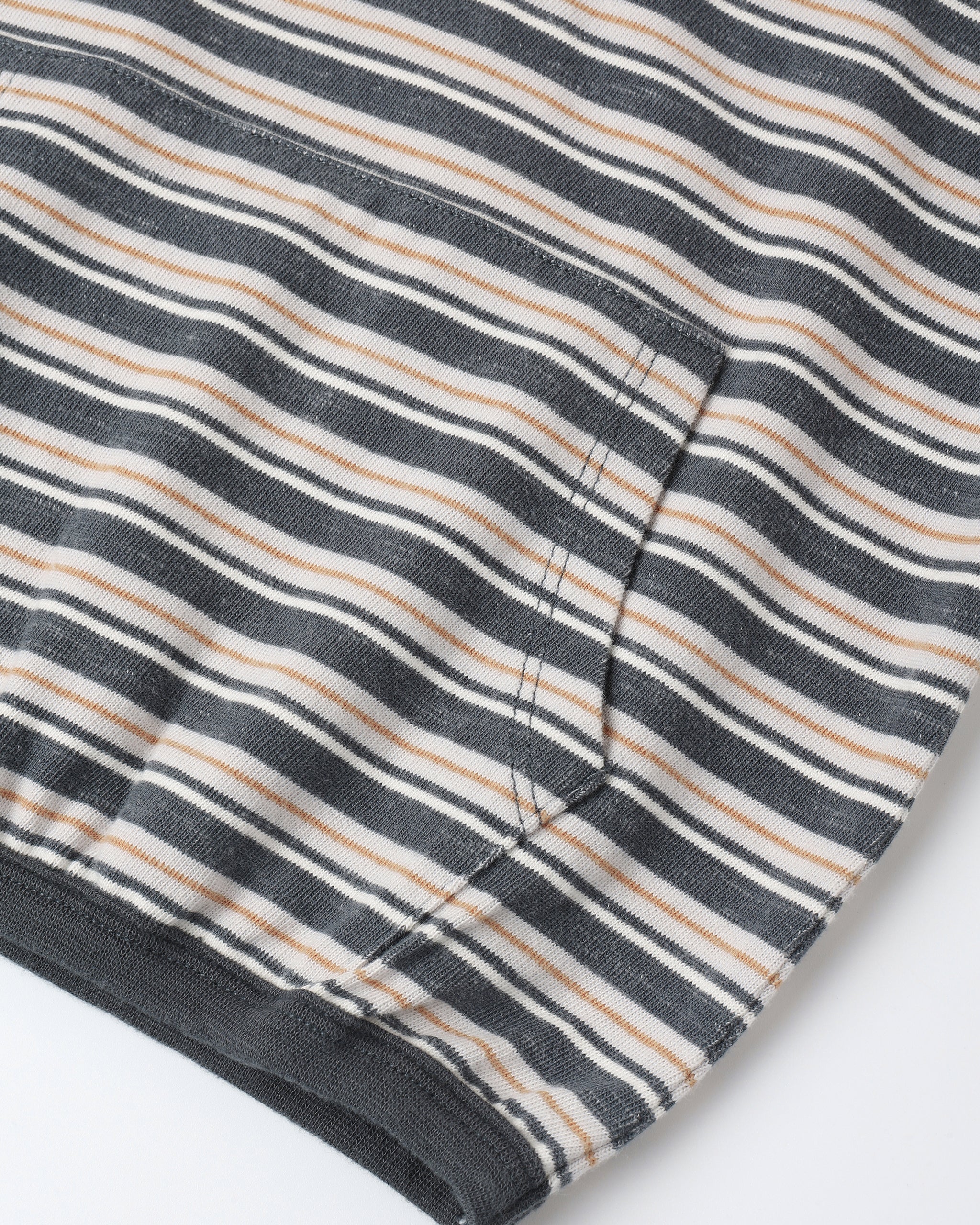 Close-up of a striped knit garment, likely a shirt or sweater sleeve, featuring horizontal stripes in charcoal gray, cream, and tan, with a dark gray ribbed collar.