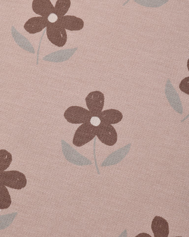 A close-up of a dusty pink fabric with a repeating pattern of dark brown flowers and light gray-green leaves.