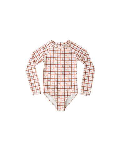 Children's swimsuit with long-sleeve top and checkered and cherry pattern on a white background