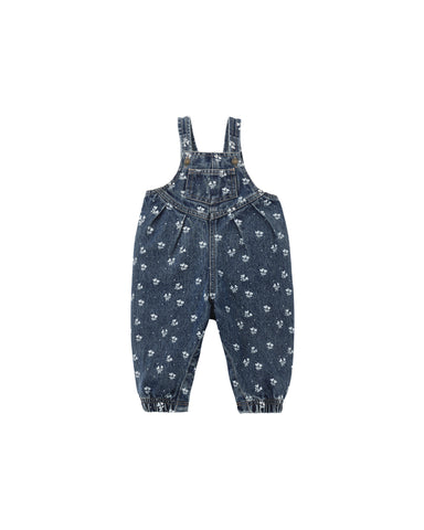 A pair of baby denim overalls in a dark blue wash, featuring an all-over small white floral pattern and elasticated ankle cuffs, shown flat on a white background.