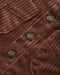 Close-up of a brown corduroy fabric with three round bronze buttons, showing the ribbed texture and stitched details.