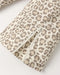 Close-up of a leopard print fabric with a silver zipper, showing a beige and brown animal pattern on a light background.