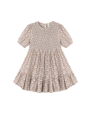 A short-sleeve babydoll dress with a smocked bodice and a tiered ruffle hem, featuring a delicate beige and brown floral pattern, shown on a plain white background.