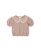 A baby knit top in dusty rose pink with a textured micro-dot pattern, featuring a cream-colored Peter Pan collar and short puff sleeves, shown against a plain white background.
