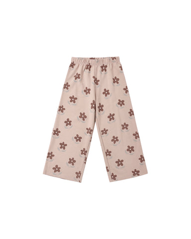 A pair of children's wide-leg pants in a light beige or dusty pink color, featuring an all-over brown flower pattern, displayed flat against a solid white background.