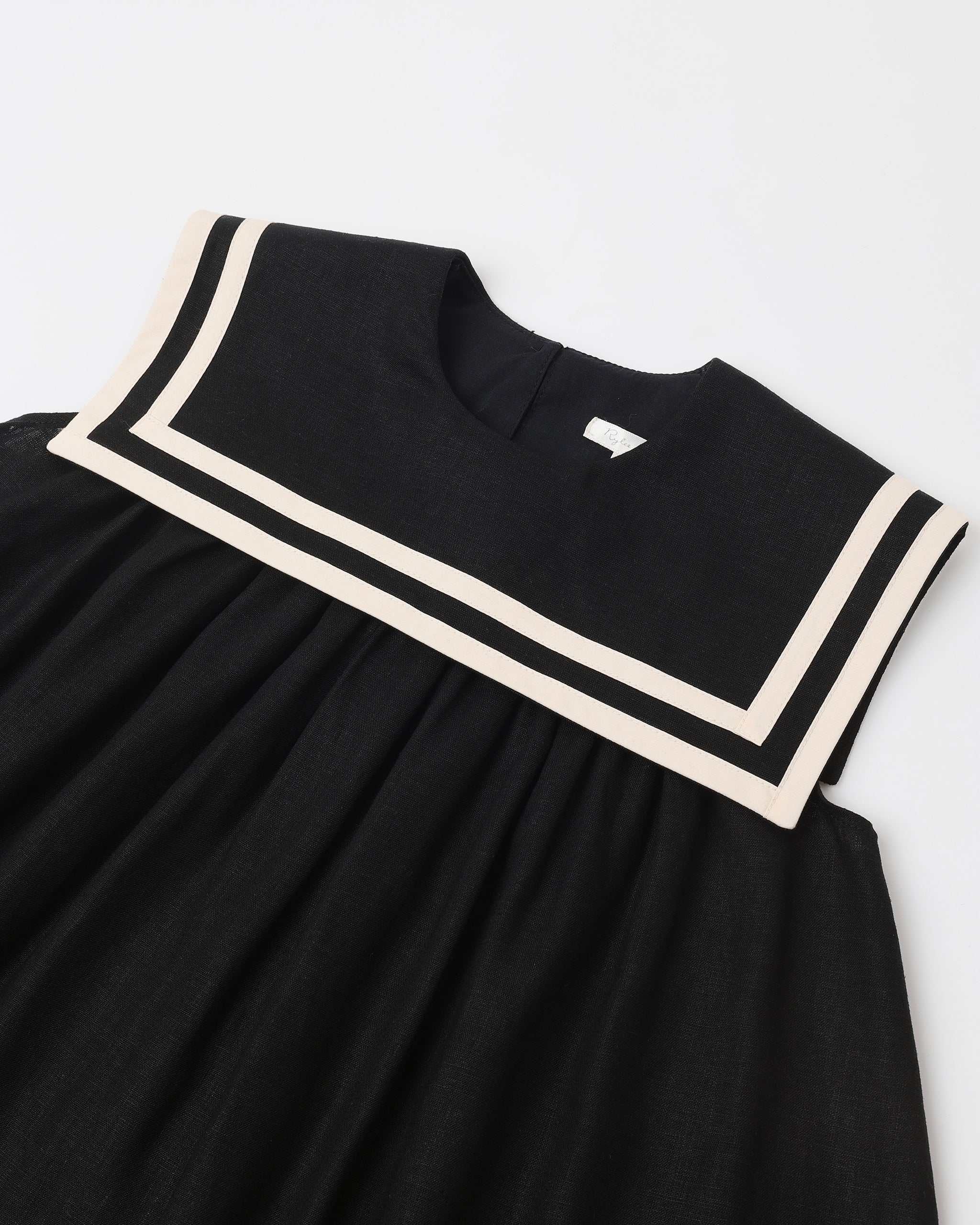 Black dress with white trim on a light gray background