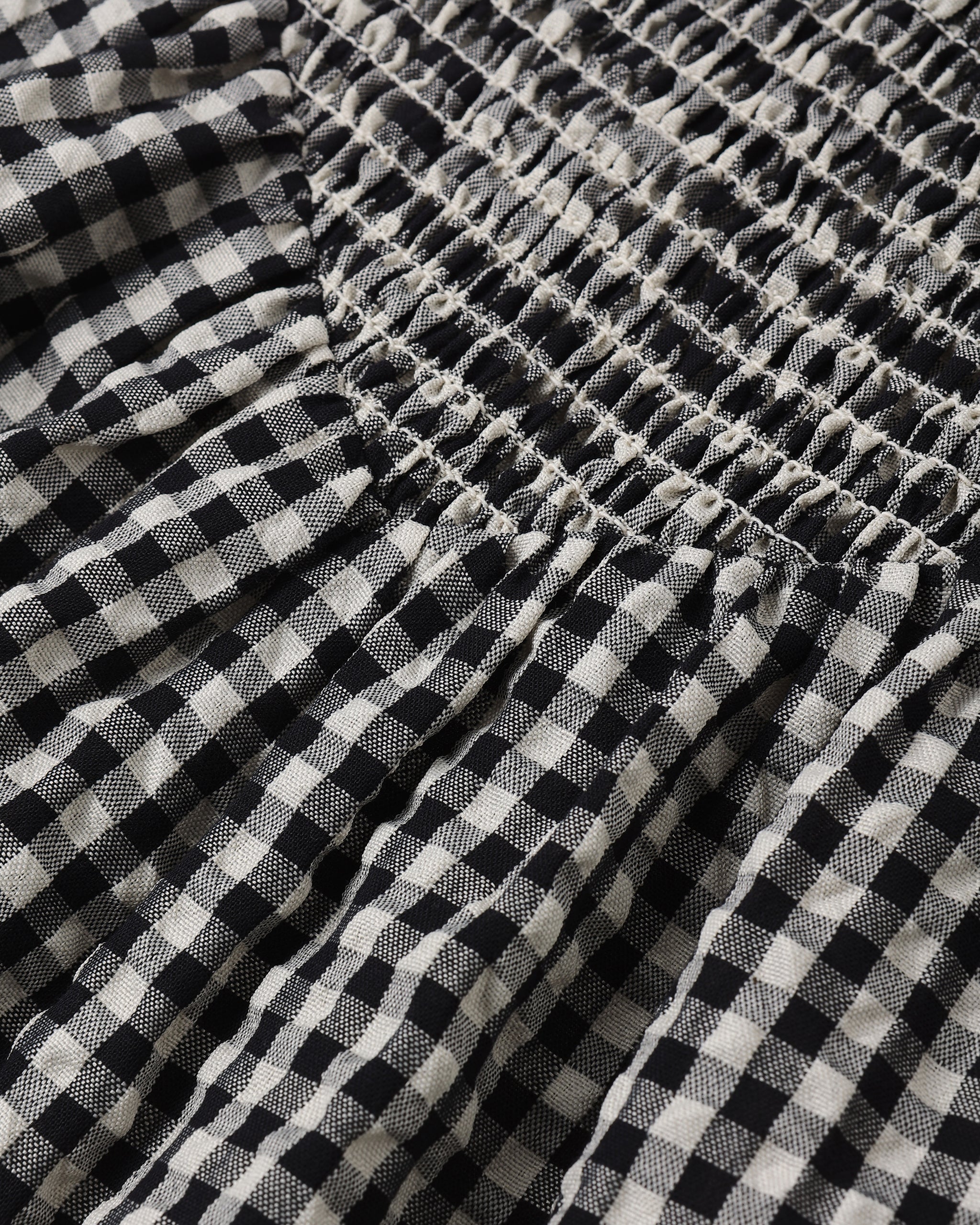 Close-up of black and white checkered fabric with a gathered waistband.