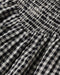 Close-up of black and white checkered fabric with a gathered waistband.