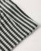 Close-up of a textured fabric with a black and off-white striped pattern and a small stitched pocket on the side, shown on a plain light background.