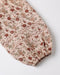 A close-up of a floral-patterned fabric sleeve or garment section with a beige base, brown and red flowers, green leaves, and lace trim, finished with an elasticized ruffled edge, photographed on a light gray background.