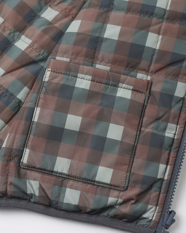 Close-up of a quilted puffer jacket with a muted plaid pattern in dusty rose, gray, and off-white, featuring a zippered pocket and dark gray trim.