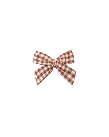 A sweet bow in a brown checked fabric attached to an alligator clip