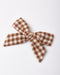 A fabric hair bow with a brown and cream gingham checkered pattern, photographed on a clean white background.