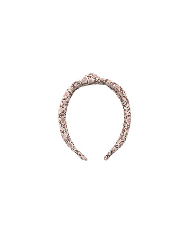 A twisted fabric headband in a dusty rose pink and white pattern, shown against a plain white background.
