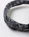 A dark gray fabric headband with a white floral and heart pattern, featuring a twisted knot detail at the front, photographed on a clean white background.