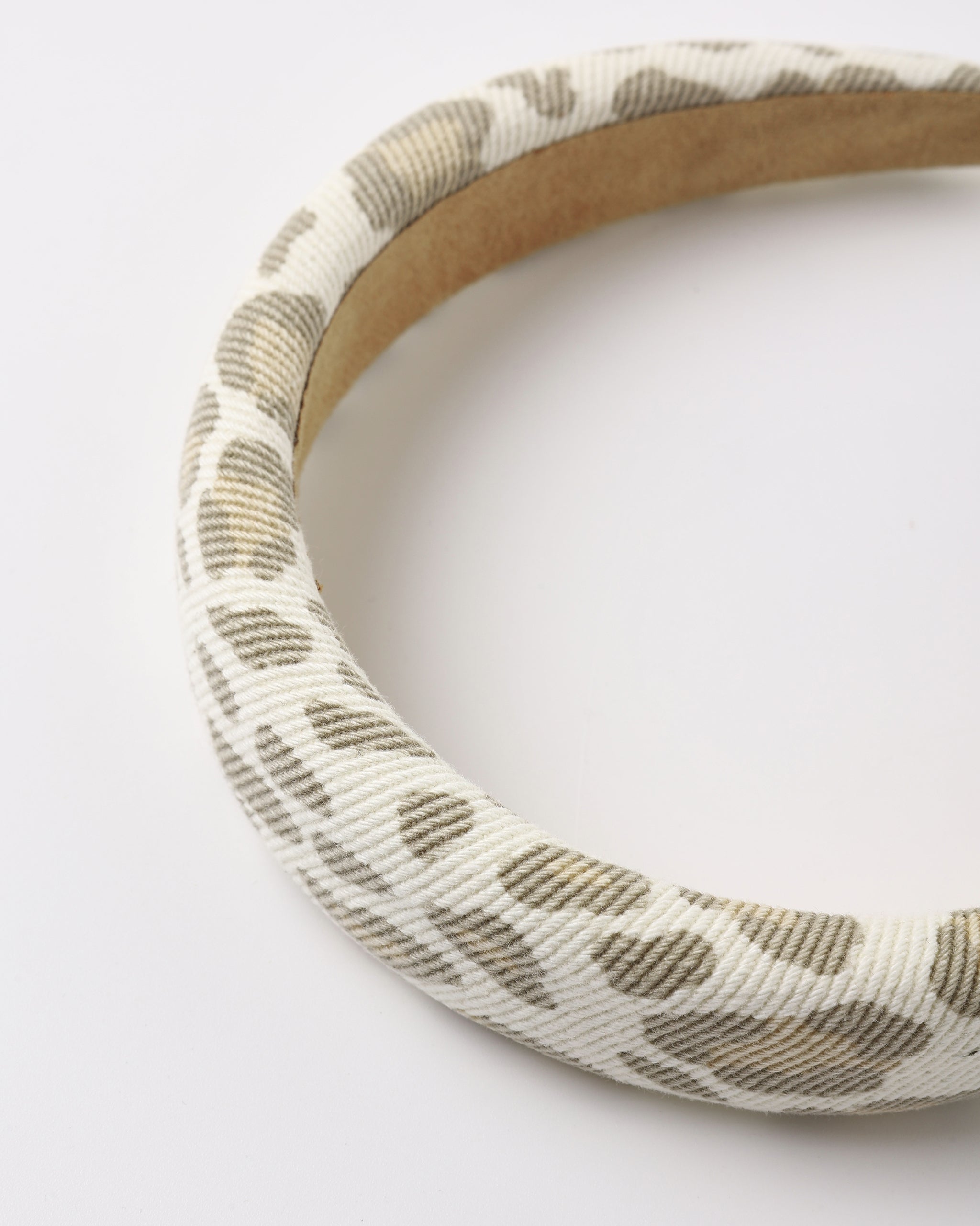 A close up of a leopard print denim padded headband shown on a white background