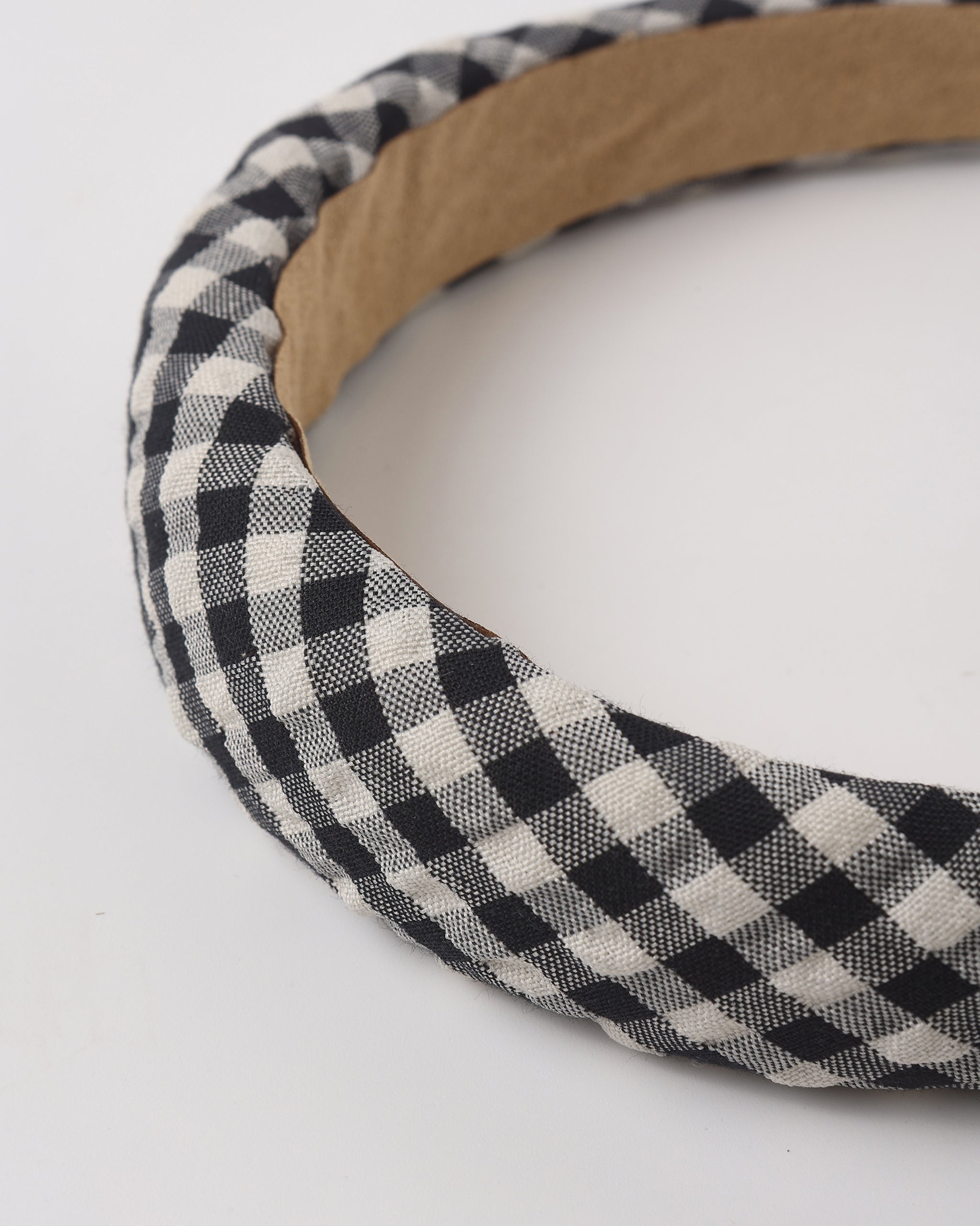 Black and white checkered headband with wooden band on a white background