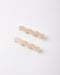 Two wavy hair clips in a light beige color, arranged diagonally on a clean white background.