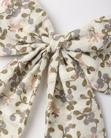 A close up of an oversized hair bow attached to an alligator clip