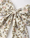 A close up of an oversized hair bow attached to an alligator clip