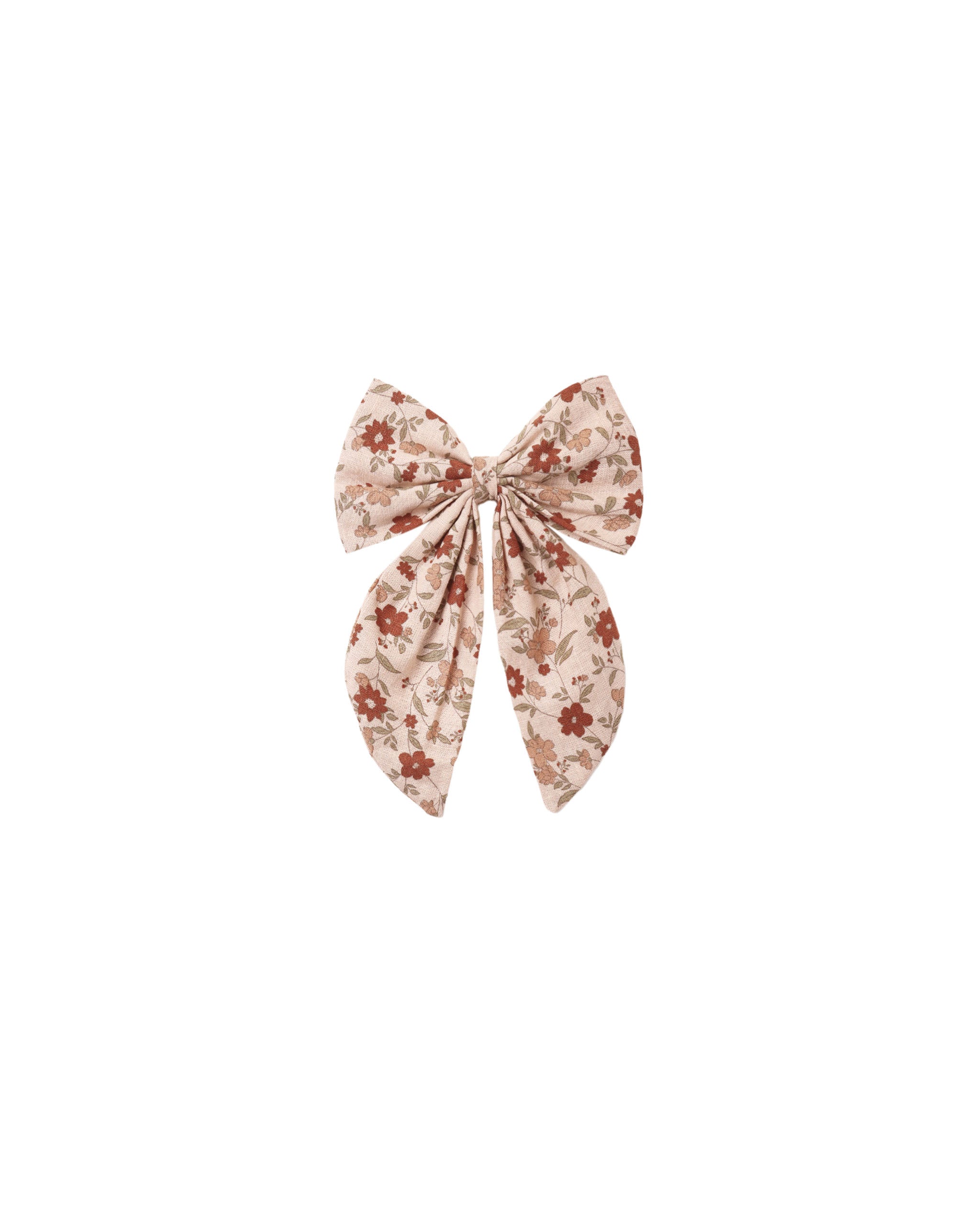 An oversized hair bow in a pink floral pattern attached to an alligator clip