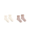 Two pairs of ribbed baby socks with ruffled trim, shown on a plain white background. One pair is off-white/cream and the other is dusty pink, both with small bow details at the top.