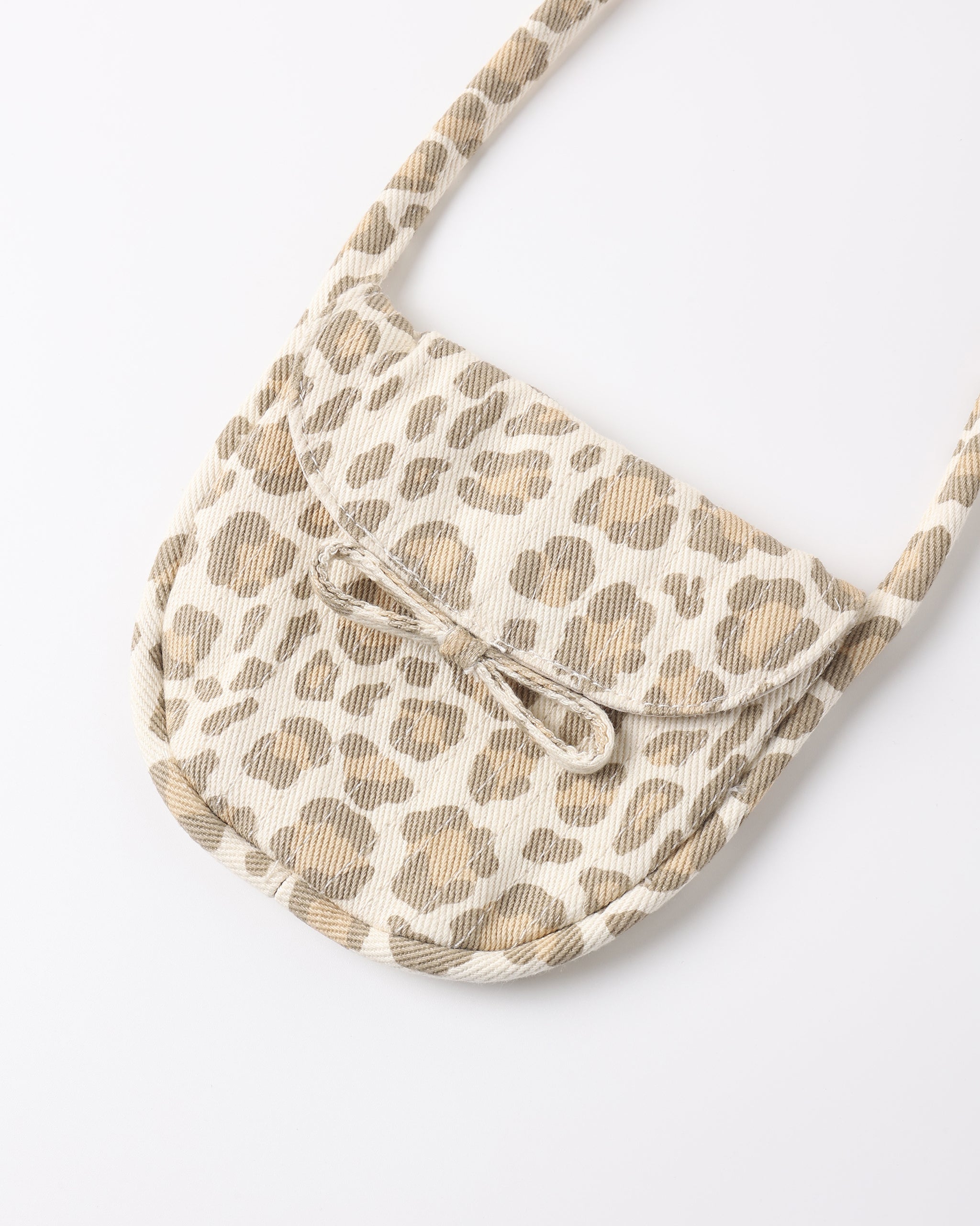 A small shoulder bag with a beige and brown leopard print pattern, featuring a flap front with a decorative bow detail and a matching shoulder strap, shown on a plain white background.