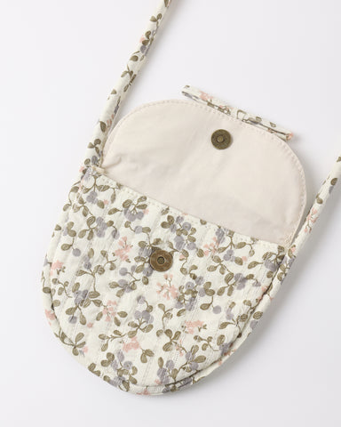 A small quilted crossbody bag with a floral patterned exterior and a solid cream-colored interior lining, featuring two metal snap buttons and a matching shoulder strap, shown on a plain white background.