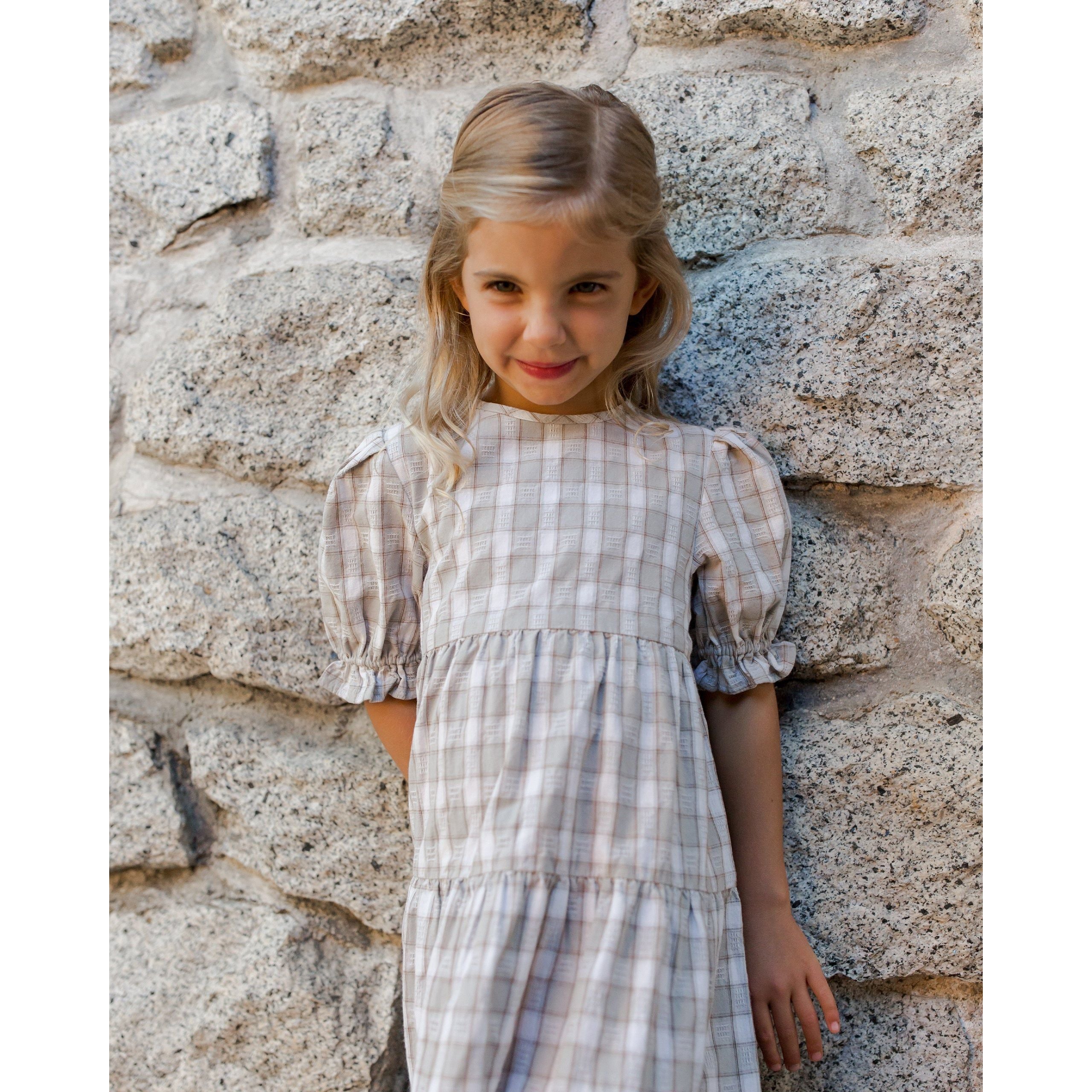 girl wearing gray and white plaid tiered maxi dress with bubble sleeve with ruffle detail