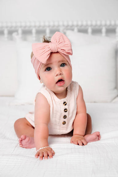 Baby girl in a rose colored cable knit headband