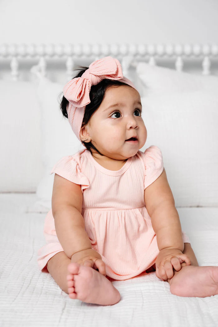 Baby girl in a rose colored cable knit headband