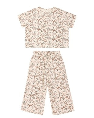 Bow and floral patterned top and pants set on a white background
