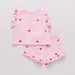 Pink children's outfit with embroidered butterflies and ruffled sleeves and shorts on a light gray background