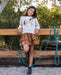 Girl wearing tiered brown corduroy skirt with a horse themed sweater
