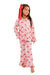 A young girl stands against a plain white studio background wearing a pink pajama set with a red bow in her hair. The pajamas have a white base with a repeating red and pink santa print.